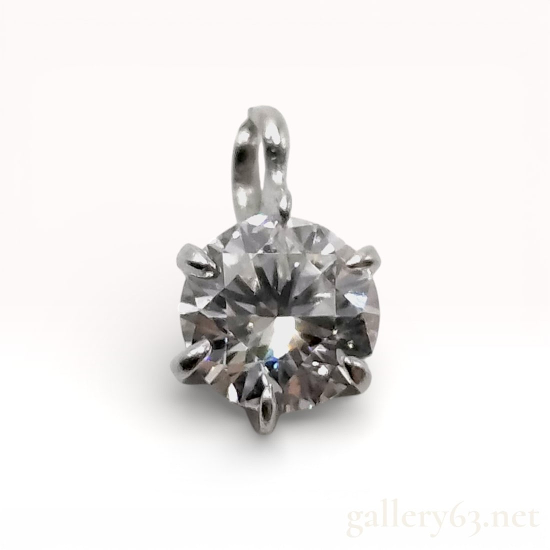 Platinum and Diamond Solitaire Pendant: Platinum and diamond solitaire pendant featuring one round brilliant cut diamond. The gemstone is secured in a six-prong basket setting with a fixed integrated bail. The reverse of the setting is insc