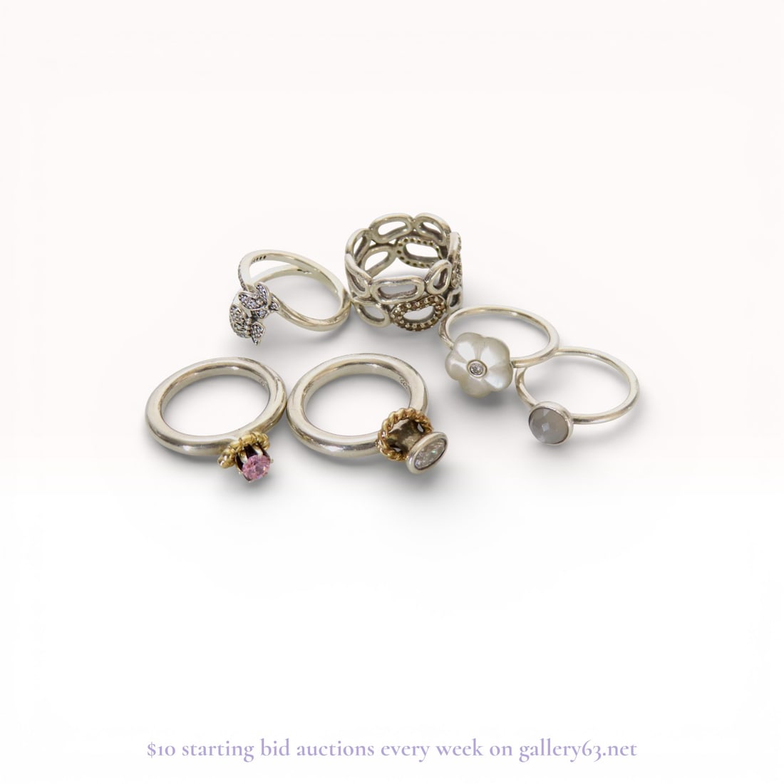 A Collection of Pandora and Sterling Silver Fashion Rings: A collection of sterling silver fashion rings, including several hallmarked Pandora pieces. The assortment features a pave-set butterfly crossover ring, a mother-of-pearl flower ring, and two crown-st