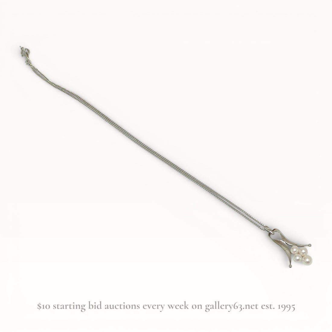 Vintage Modernist Silver and Cultured Pearl Pendant Necklace: Vintage modernist silver pendant necklace featuring an abstract foliate-inspired setting, mid-20th century. The pendant is set with four round white cultured pearls and is suspended from a fine double