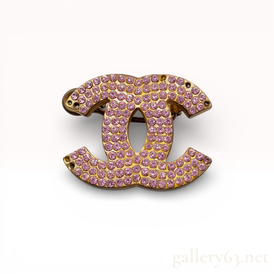 Chanel Pink Crystal Pave CC Logo Brooch: Chanel interlocking double CC logo brooch from the Spring 2002 collection. The gold-tone base metal frame is pave-set with round-cut pink crystals and features a trombone-style pull-release safety cla