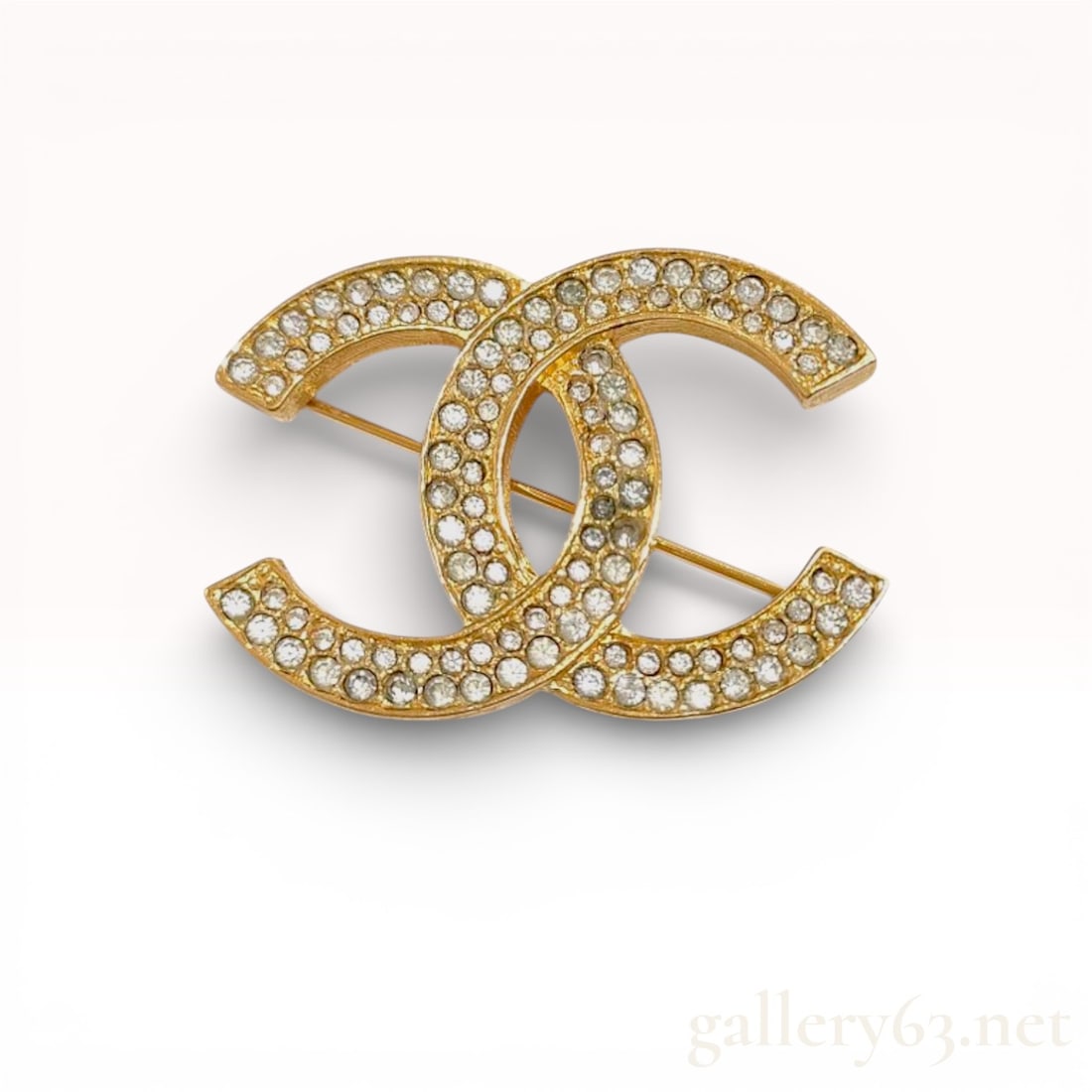 Chanel Vintage Gold Plated Rhinestone CC Logo Brooch: Chanel interlocking CC logo brooch, circa late 1970s to early 1980s. The gold-plated base metal features a textured bark-like finish on the sides and reverse, with the front pave-set with clear round