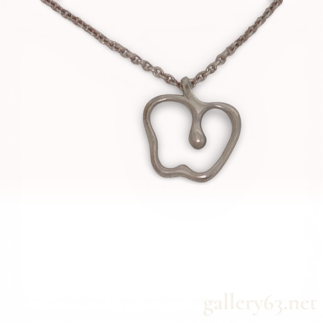 Tiffany and Co. Elsa Peretti Sterling Silver Apple Pendant Necklace: Tiffany and Co. sterling silver Apple pendant necklace designed by Elsa Peretti. The openwork apple pendant features a central drop element and is suspended from a fine sterling silver cable link chai