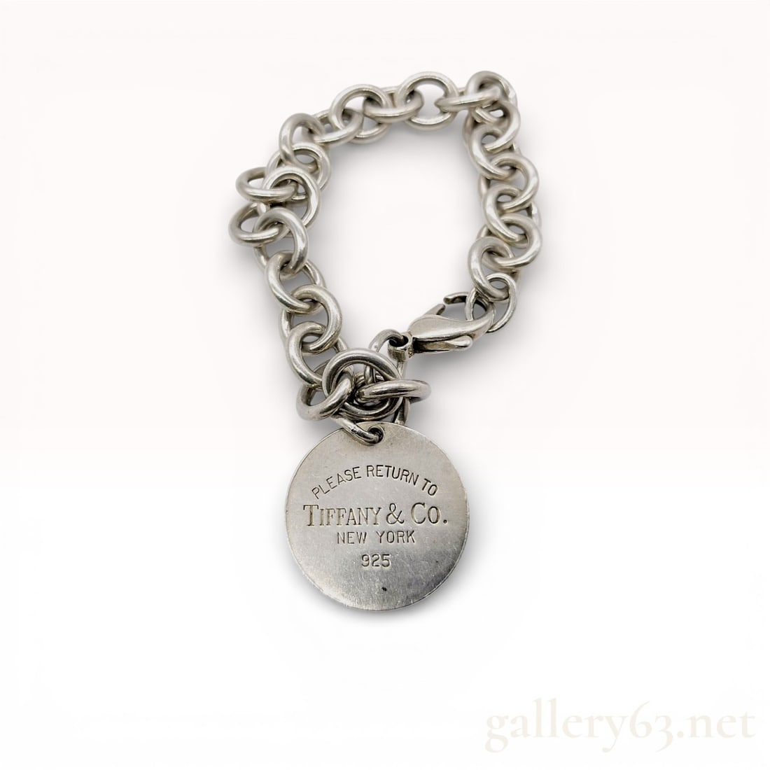 Tiffany and Co. Sterling Silver Return to Tiffany Round Tag Bracelet: Tiffany and Co. sterling silver Return to Tiffany round tag bracelet, modern period. The piece features a classic round link chain supporting a circular charm and is secured with a lobster claw clasp.