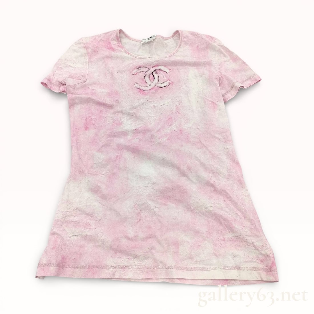 Chanel Pink Tie-Dye Cotton Logo T-Shirt: Chanel short-sleeved crew-neck t-shirt featuring a pink and white marbleized tie-dye pattern. The center chest is decorated with a large interlocking CC logo in a distressed painterly aesthetic with d
