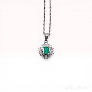 Emerald and Diamond Cluster Pendant Necklace in Platinum: Platinum pendant necklace featuring a central rectangular emerald-cut green gemstone within a tiered cluster of round brilliant and tapered baguette diamonds. The pendant is suspended on a platinum