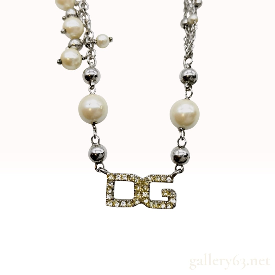 Dolce & Gabbana Sterling Silver and Faux Pearl DG Necklace: Dolce & Gabbana sterling silver necklace featuring a central DG logo pendant pave-set with clear rhinestones. The double cable chain is accented with polished metal beads, imitation pearls of vari