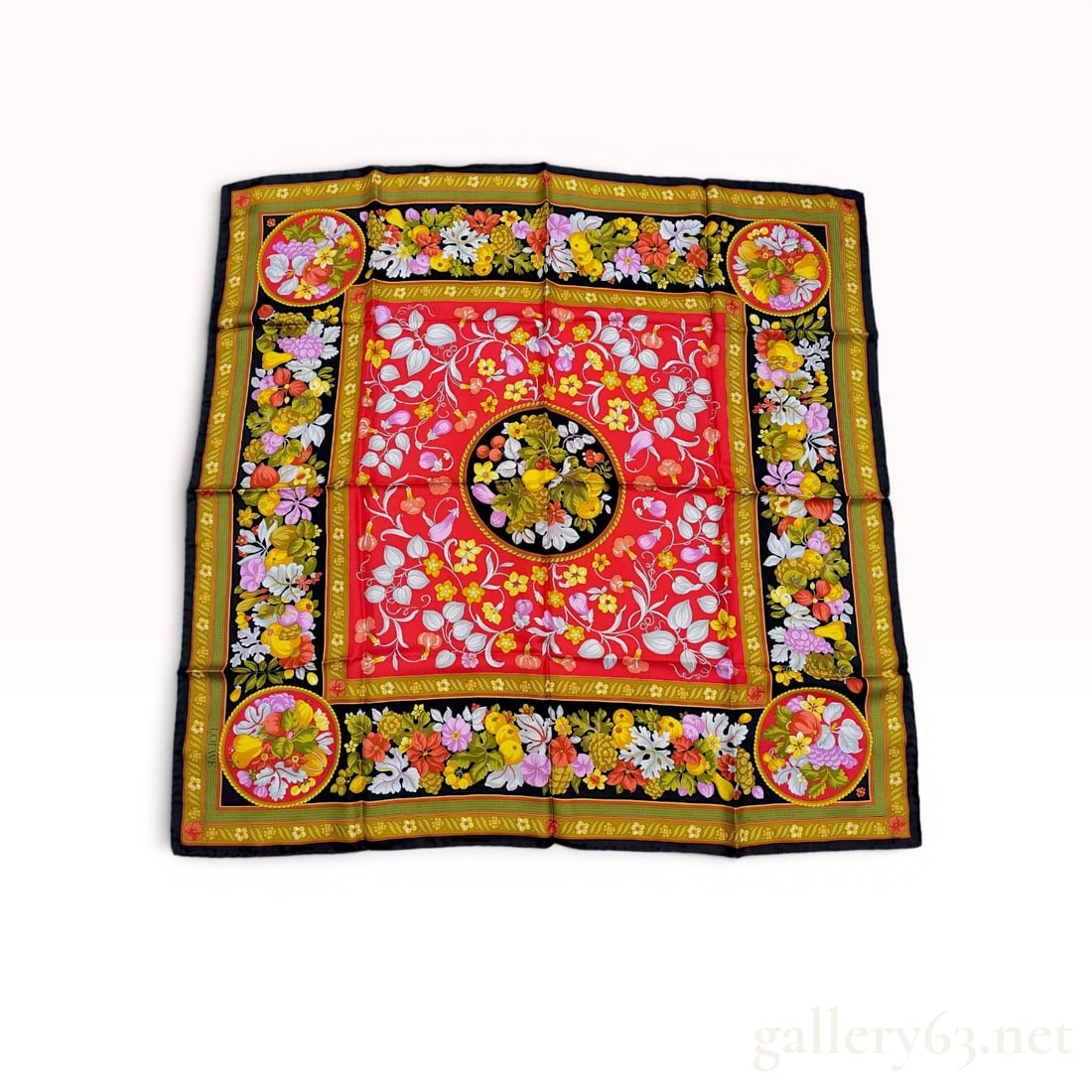 Loewe Square Silk Scarf with Botanical and Fruit Motif: Loewe square silk scarf featuring a vibrant botanical and fruit motif. The design incorporates a red central field with floral vines surrounded by black borders with garlands of grapes, pears, and blo