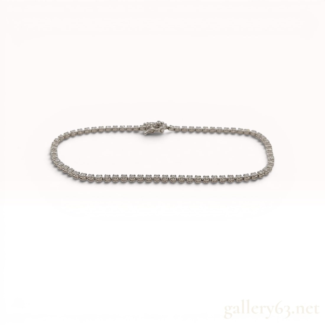 Diamond Tennis Bracelet in Pt850 Platinum: Diamond tennis bracelet featuring a continuous line of round brilliant cut diamonds set in Pt850 platinum. Each stone is individually secured in a four-prong basket mount, and the piece is finished wi