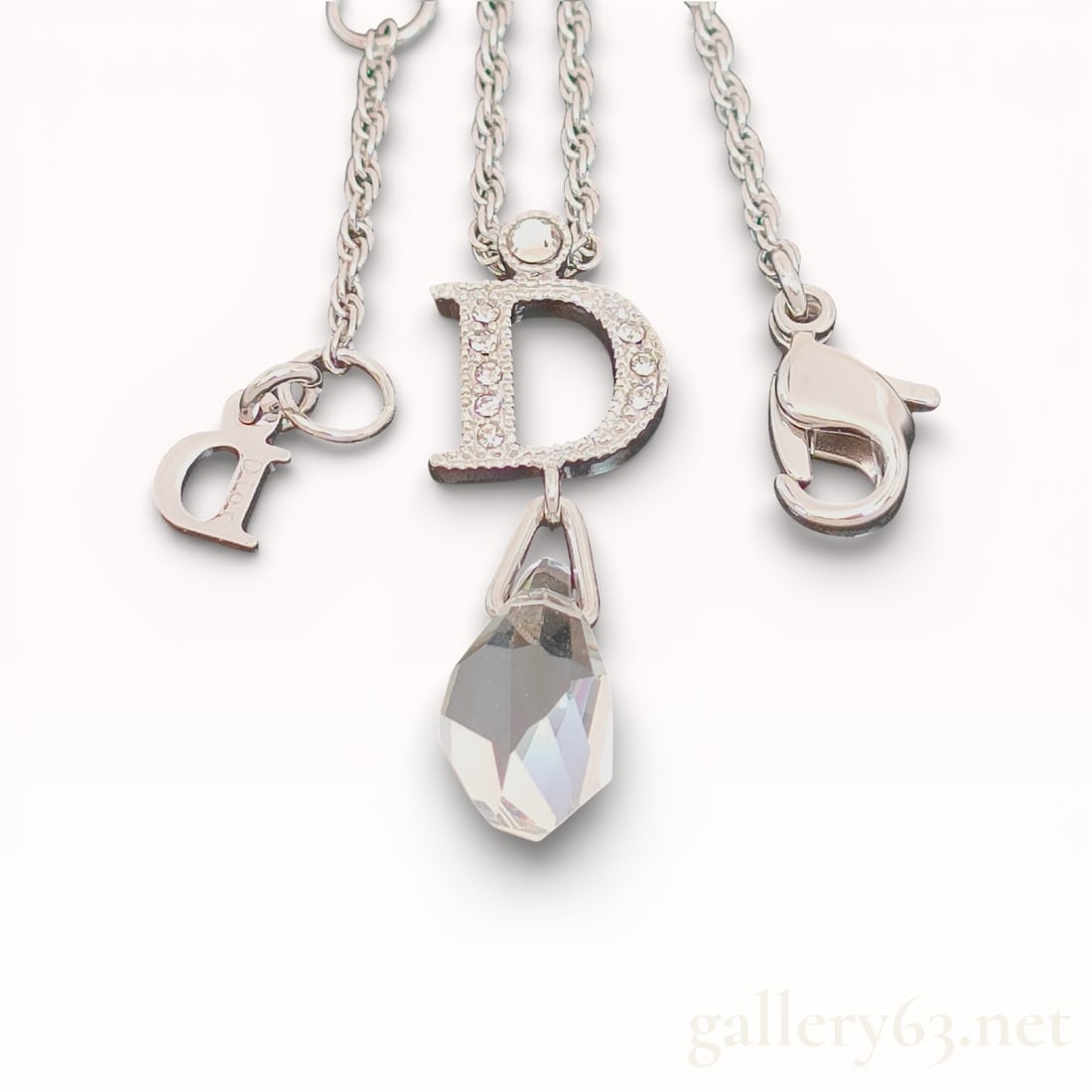 Dior Silver Color Swing Clear Stone & Logo Pendant 21 inch Necklace With Box: Authentic Dior necklace, featuring a letter-form pendant set with small clear stones and a suspended faceted clear drop below. Design including additional small letter charms attached along the chain,