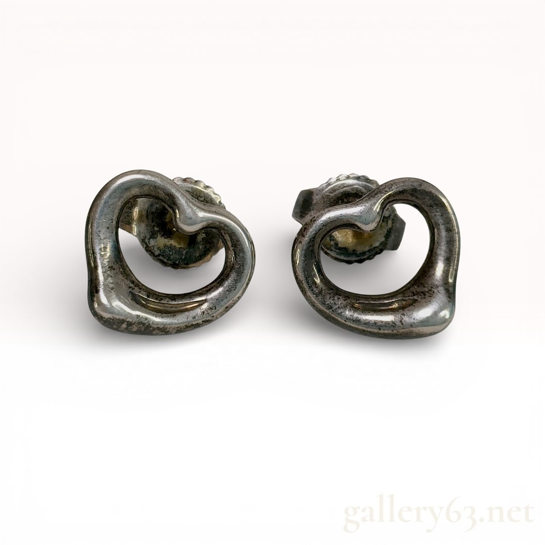 Sterling Silver Stud Earrings, Tiffany & Co. Elsa Peretti Open Heart: A matched pair of sterling silver stud earrings featuring the iconic Open Heart motif designed by Elsa Peretti for Tiffany & Co. The earrings are crafted from .925 sterling silver and feature a po