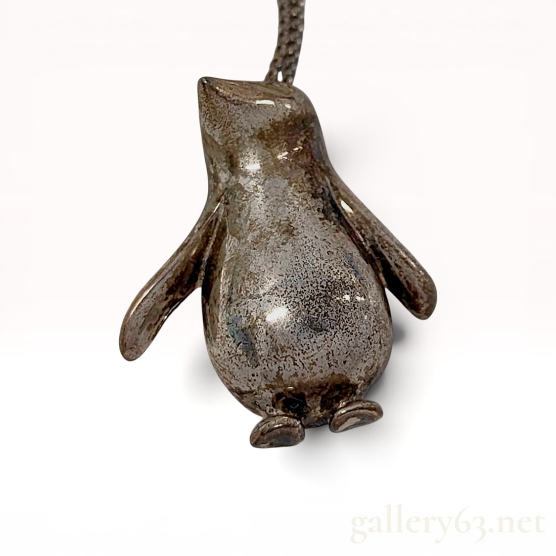 Tiffany & Co. Sterling Silver Penguin Pendant Necklace: Tiffany & Co. sterling silver figural penguin pendant necklace. The hollow-back pendant is suspended from a fine cable link chain with a spring ring clasp and a branded metal tag. The interior rev