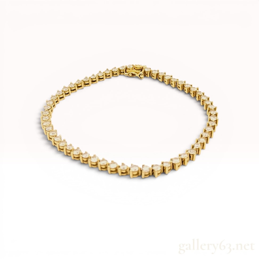 An 18 Karat Yellow Gold and 3.10ctw Diamond Tennis Bracelet w/Box: An 18 karat yellow gold tennis bracelet featuring a continuous row of round brilliant-cut diamonds. Each diamond is secured in a four-prong basket setting, terminating in an integrated box clasp with 