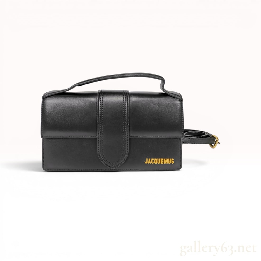 Jacquemus Le Grand Bambino Black Leather Top-Handle Bag: Jacquemus Le Grand Bambino top-handle bag, contemporary. Structured rectangular design of smooth black leather featuring a magnetic fold-over flap with a decorative vertical strap and gold-toned logo 