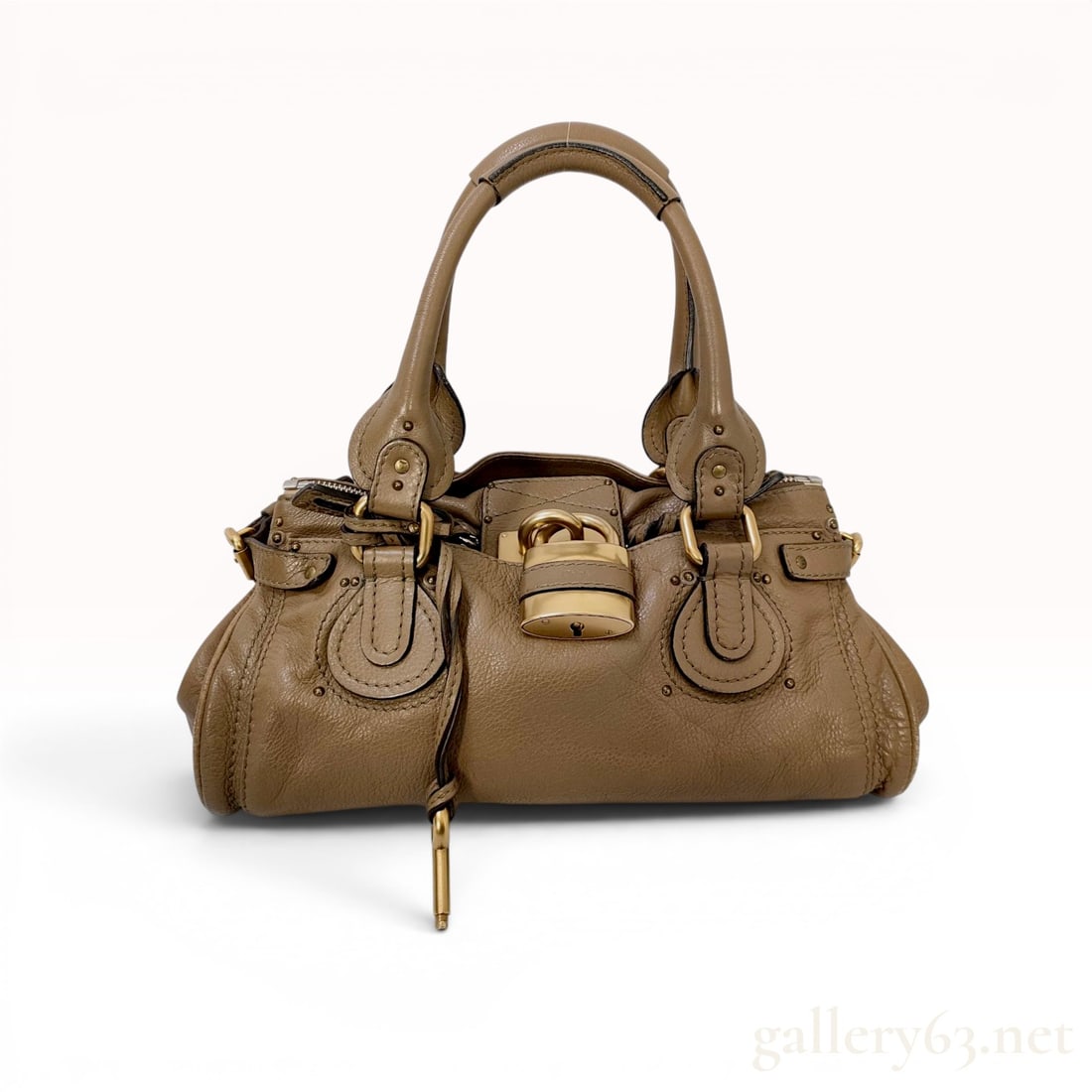 Chloe Taupe Grained Leather Paddington Satchel: A Chlo?© Paddington satchel crafted from taupe pebbled calfskin leather featuring antiqued brass-tone hardware. The bag is designed with dual rolled handles, decorative stud detailing, and a signatur