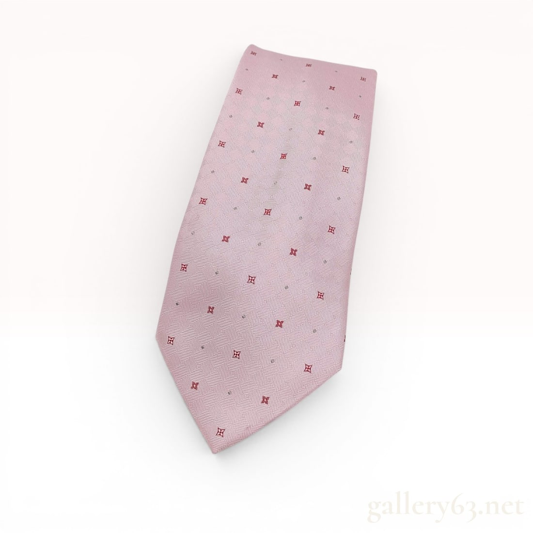 Louis Vuitton Pink Silk Geometric Quatrefoil Motif Necktie: A designer men's necktie by Louis Vuitton. The tie is constructed from light pink silk featuring a tonal, textured geometric weave of concentric squares. The surface is decorated with a repeating patt