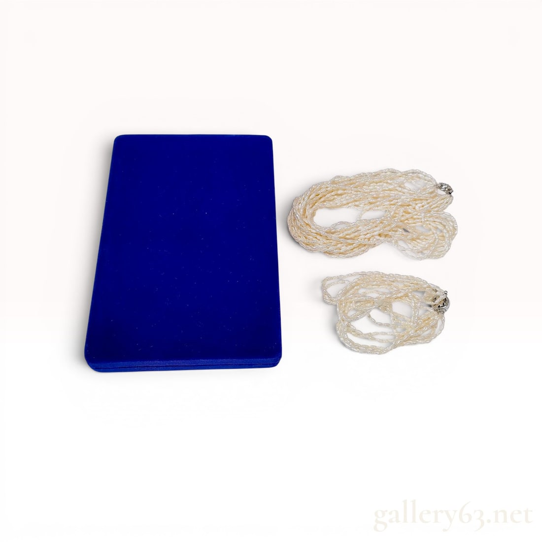 A Pair of Multi-Strand Freshwater Keshi Pearl Jewelry Items comprising a Necklace and Bracelet w/Box: Multi-strand necklace and matching bracelet suite featuring iridescent cream-colored freshwater keshi pearls. Both pieces are constructed with approximately ten to twelve strands of rice-shaped pearls