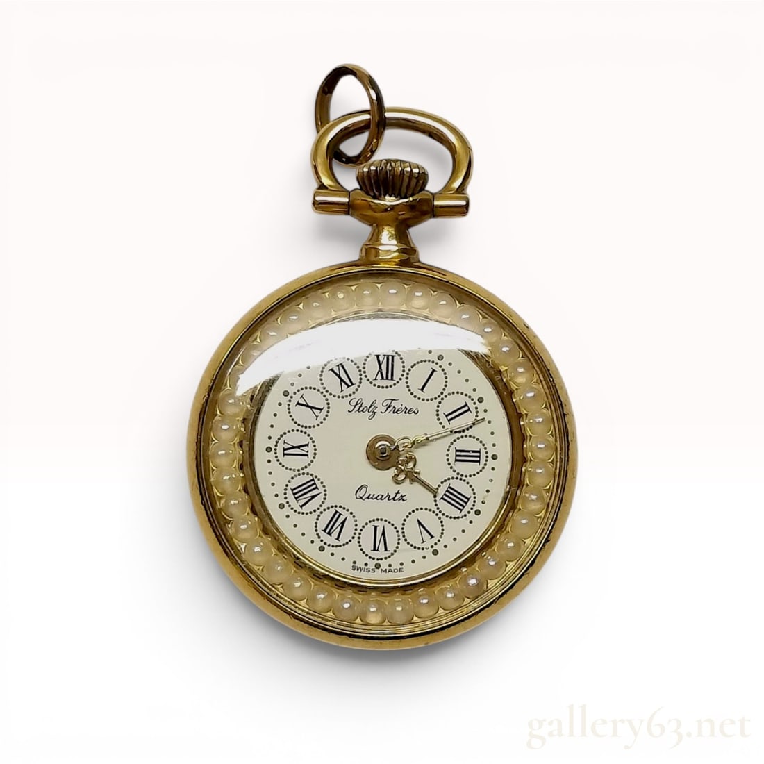 Stolz Freres Swiss Made Gold Tone and Enamel Quartz Pendant Watch: Stolz Freres Swiss made pendant watch with a quartz movement. The round gold-tone metal case features a bezel set with a continuous ring of small white cabochon beads and a dark green marbled enamel r