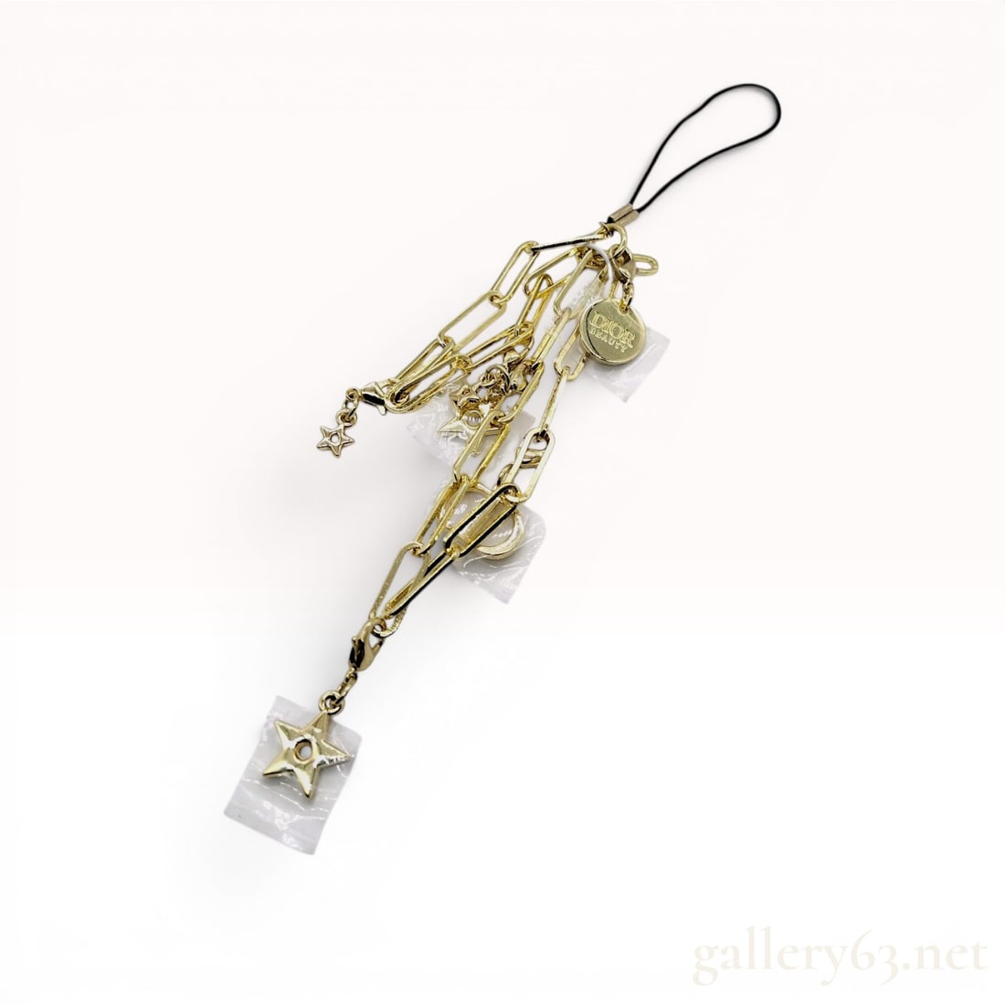 Dior Beauty Gold-Tone Multi-Charm Phone Strap and Box: Dior Beauty gold-tone multi-strand charm accessory with original presentation box. Composed of various lengths of paperclip-style chain adorned with five-pointed star charms, an interlocking CD logo, 