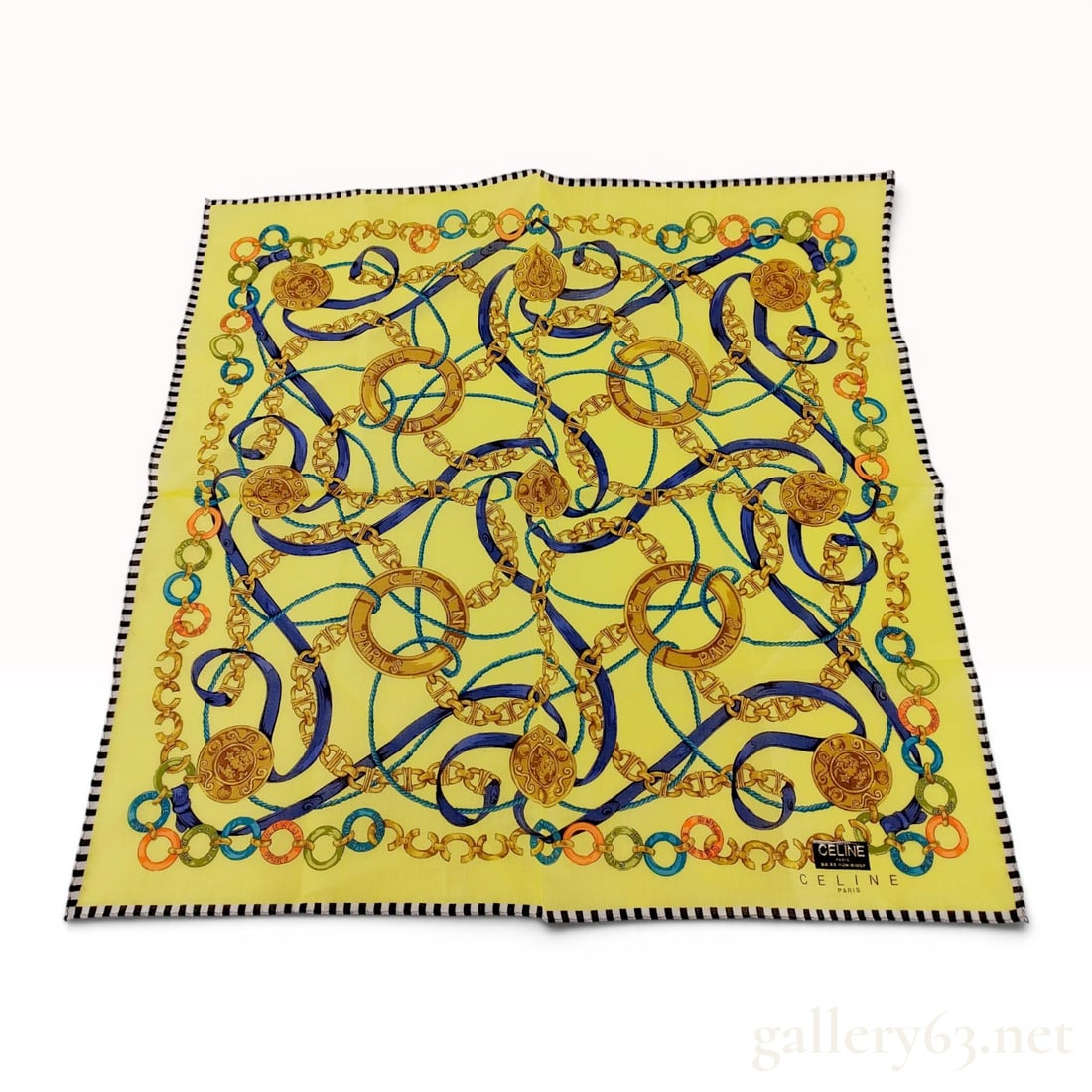 Celine Paris Cotton Scarf with Nautical Chain and Strap Motif: Celine Paris square cotton scarf or pocket square featuring a nautical-inspired motif of intertwined gold-tone chains, blue buckled straps, and turquoise ropes on a yellow field. The design is accente