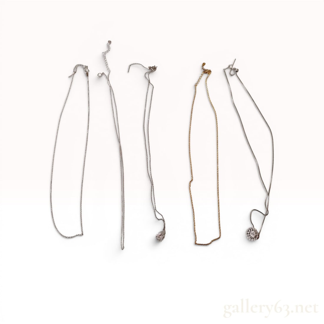 A Collection of Five Sterling Silver Necklaces w/Box: Collection of five contemporary sterling silver necklaces including four silver-toned and one gold-plated silver example. Two necklaces feature clear faceted gemstone pendants including a pear-cut sol