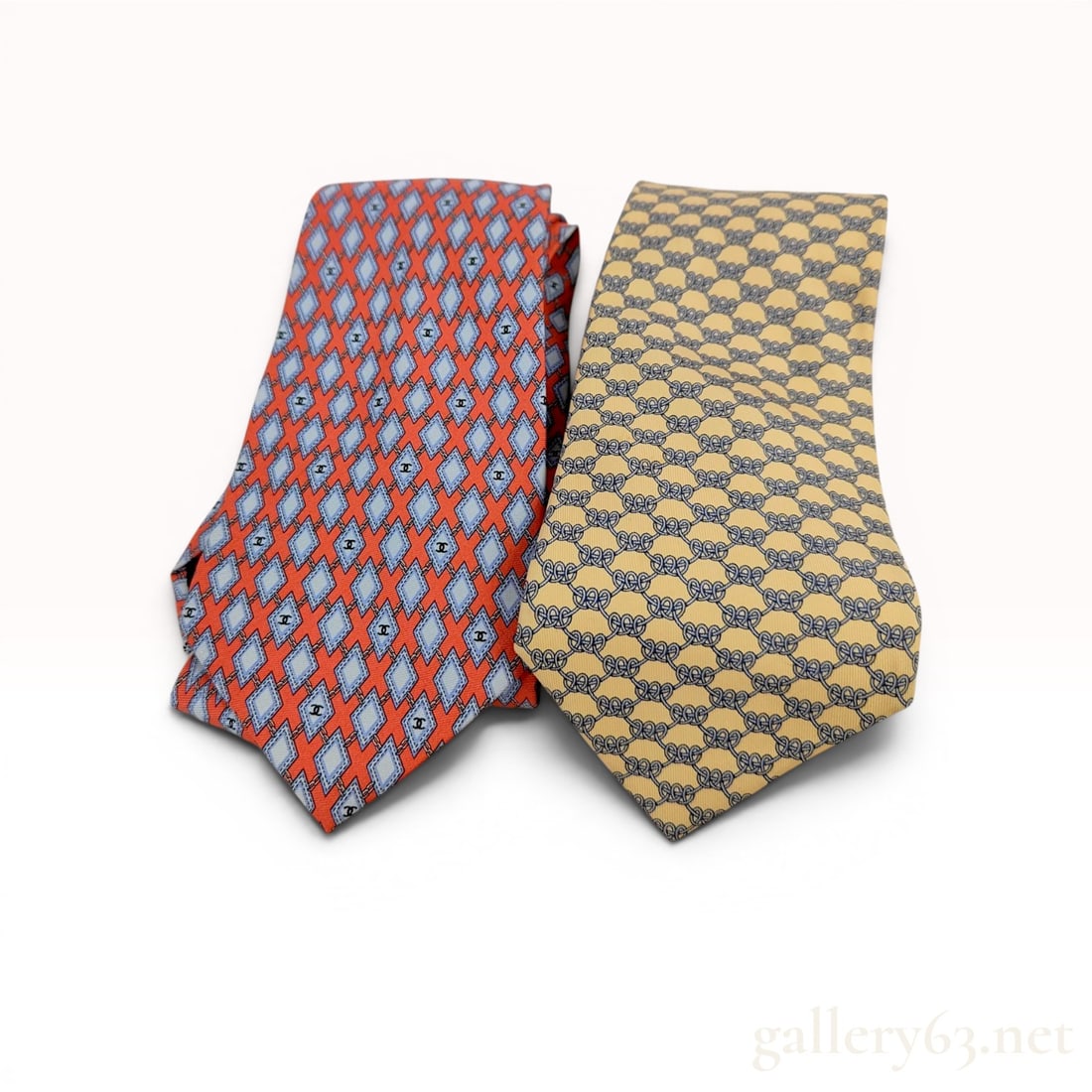 Two Luxury Silk Neckties by Chanel and Hermes: Two 100% silk neckties by Chanel and Hermès. The Italian-made Chanel tie features an orange-red geometric diamond pattern with interlocking CC logos and a signature gold-tone chain weight. The 