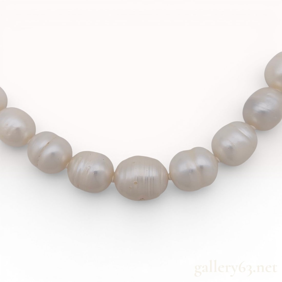 Cultured 10mm Freshwater Baroque Pearl Necklace with Silver Clasp w/Box: A single strand cultured freshwater pearl necklace featuring baroque-style pearls. The pearls are characterized by a ringed or barrel shape with visible natural growth rings and surface grooves. They 
