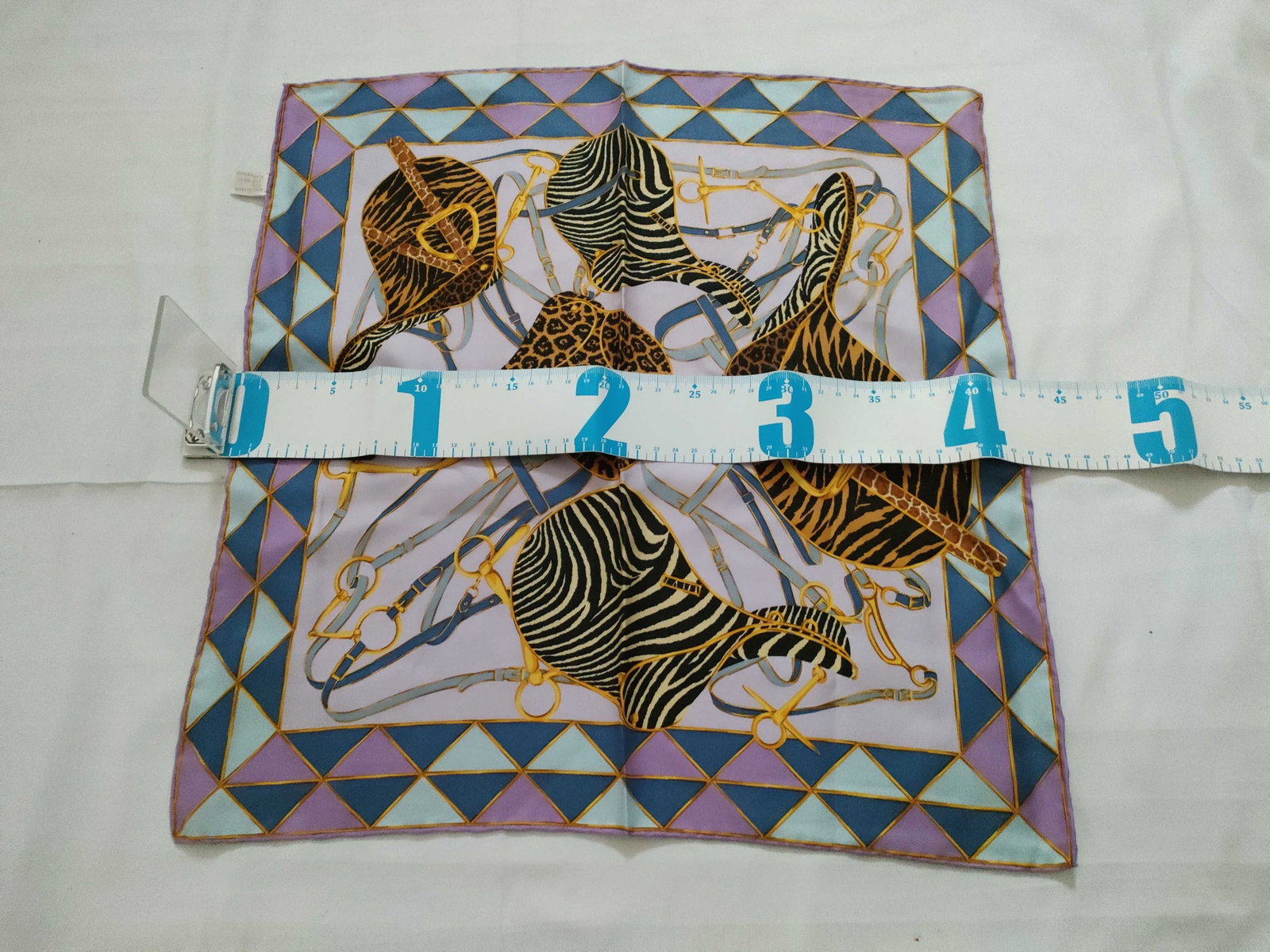 Gucci Italian Silk Pocket Square Scarf with Equestrian and Animal Print Motif: A Gucci printed silk square scarf, functioning as a pocket square or small neck scarf. The central design is set against a pale lavender ground and features an equestrian theme. Motifs include stylize