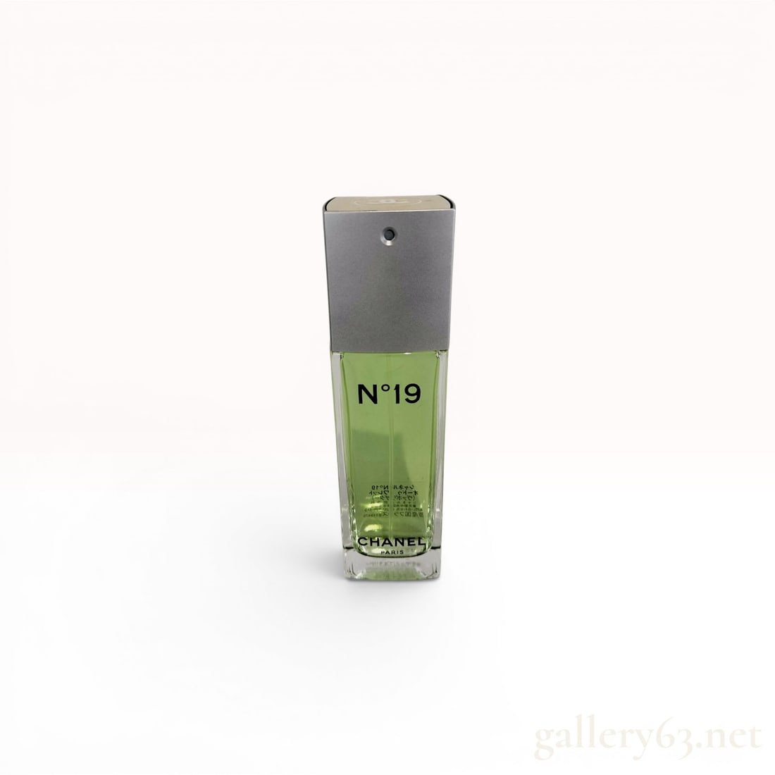 Chanel No.19 Eau de Toilette Spray, 100 ml: A bottle of Chanel N°19 Eau de Toilette. The fragrance is housed in a tall, rectangular clear glass bottle containing a light green liquid. It is fitted with a matte silver-tone spray cap featurin