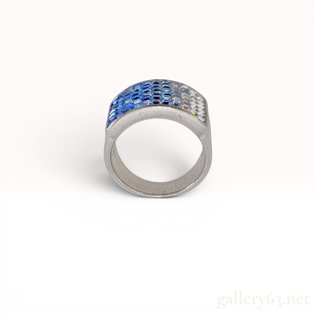Sterling Silver Gradient Band Ring: Sterling silver fashion ring featuring a rectangular field of square-cut stones in a grid setting. The stones exhibit a horizontal color gradient transitioning from deep cobalt blue to light blue and 