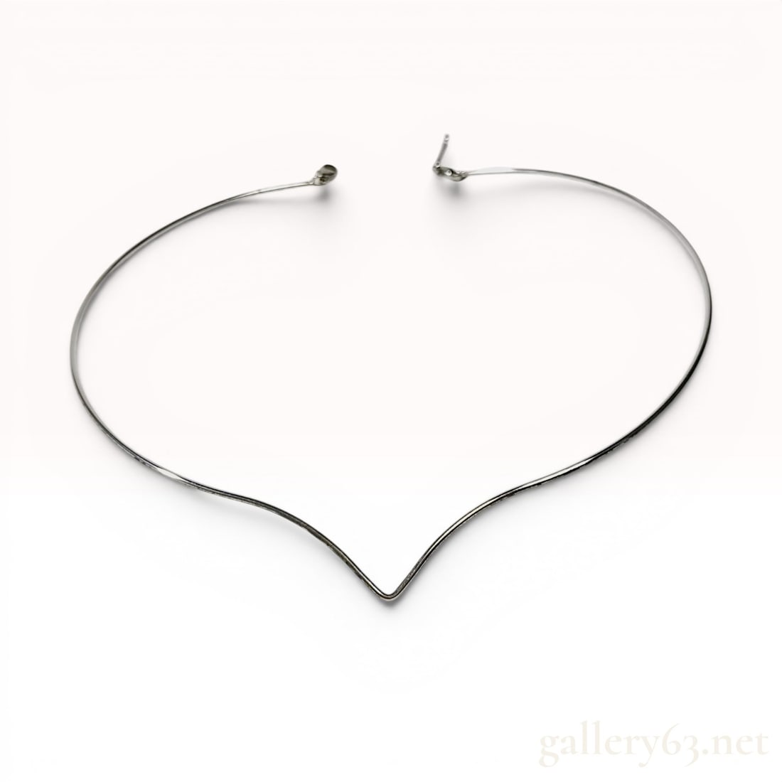 Silver-Tone Metal V-Shape Neckwire Collar Necklace: Modern V-shape neckwire collar necklace in silver-tone metal. The rigid wire piece features a central notched point and secures with a lobster claw clasp on a short extender bar. No visible hallmarks,