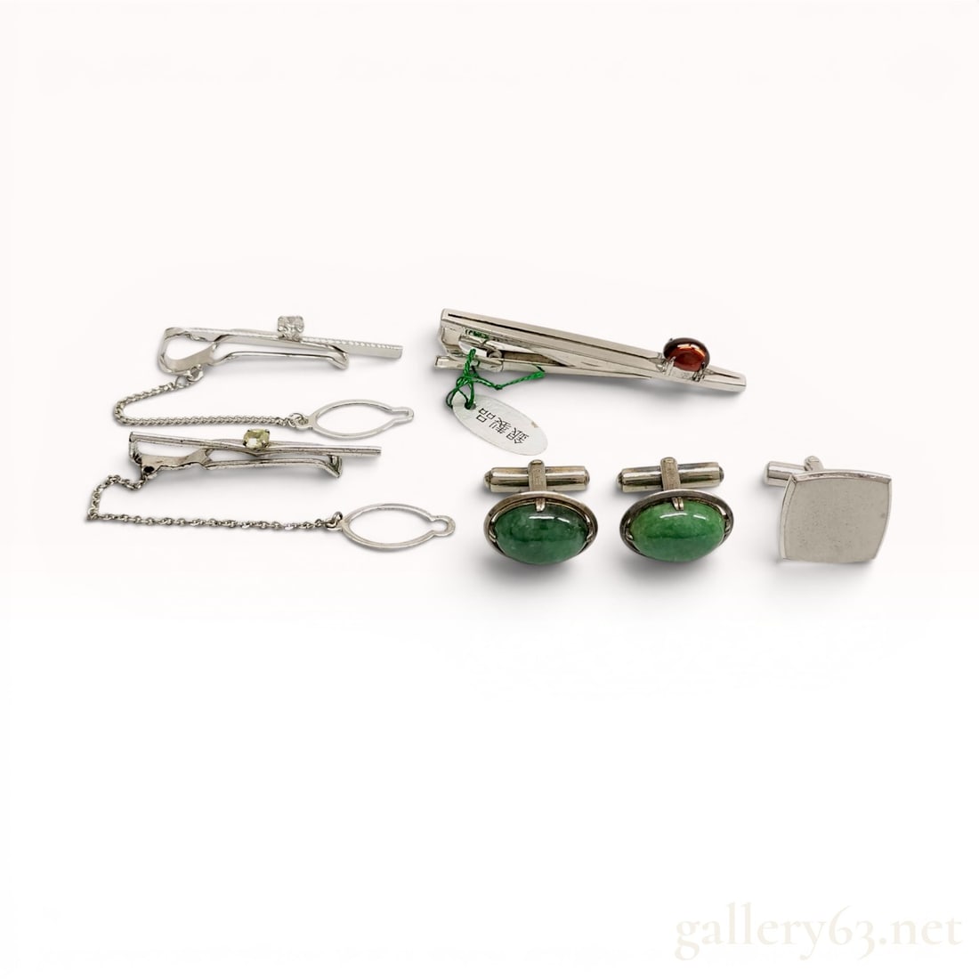 A Collection of Vintage Silver Men's Jewelry Accessories: A collection of vintage men's jewelry including three tie bars and three cufflinks, mid-to-late 20th century. The assortment features silver-toned metal settings accented by various gemstones, includi