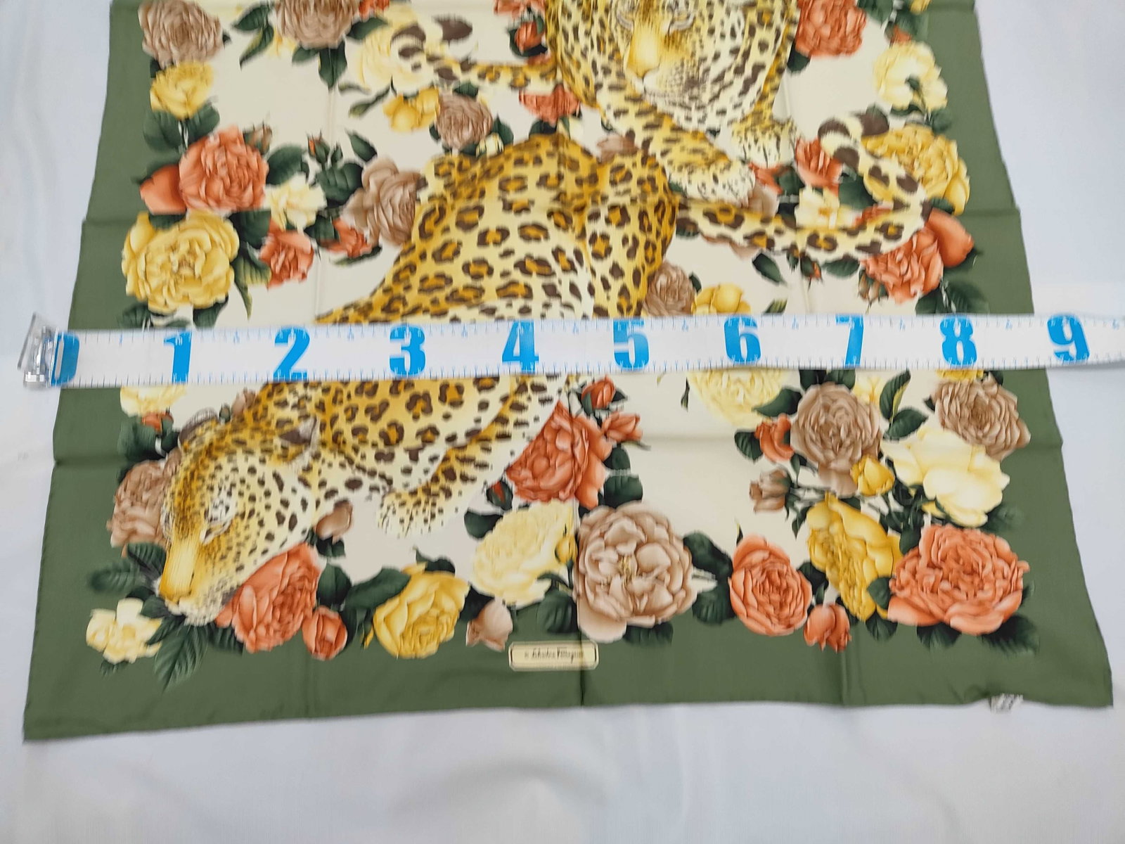 Salvatore Ferragamo Silk Leopard and Floral Motif Scarf w/Box: Salvatore Ferragamo square silk scarf featuring a leopard and floral motif. The print depicts two leopards among rose blossoms in yellow, cream, and coral tones on an ivory ground with a wide sage gre
