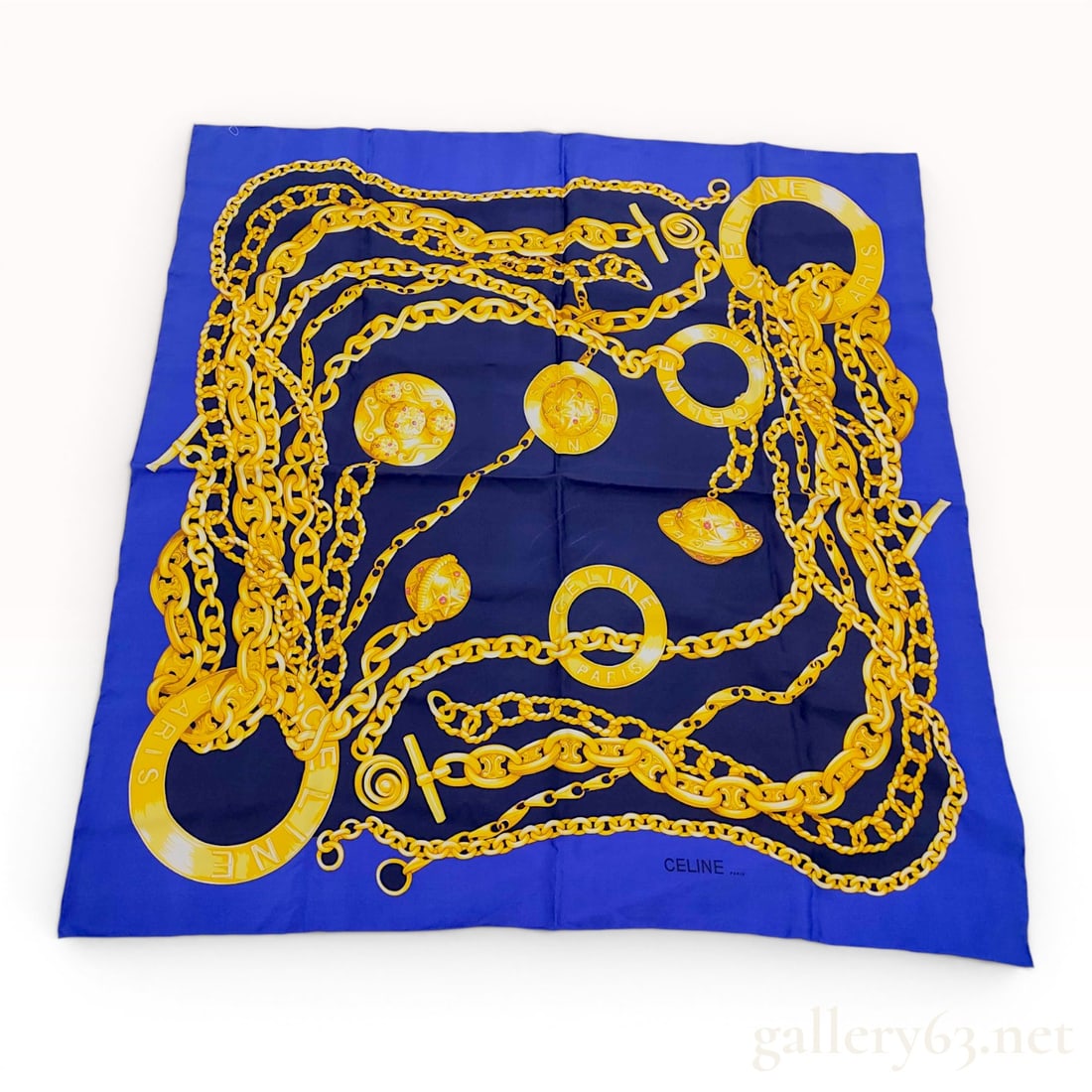 Celine Vintage French Silk Scarf with Golden Chain and Medallion Motif: This vintage silk scarf from Celine Paris features an elaborate nautical and celestial-inspired design. The central navy blue field is decorated with multiple interwoven golden chain links, rings, and