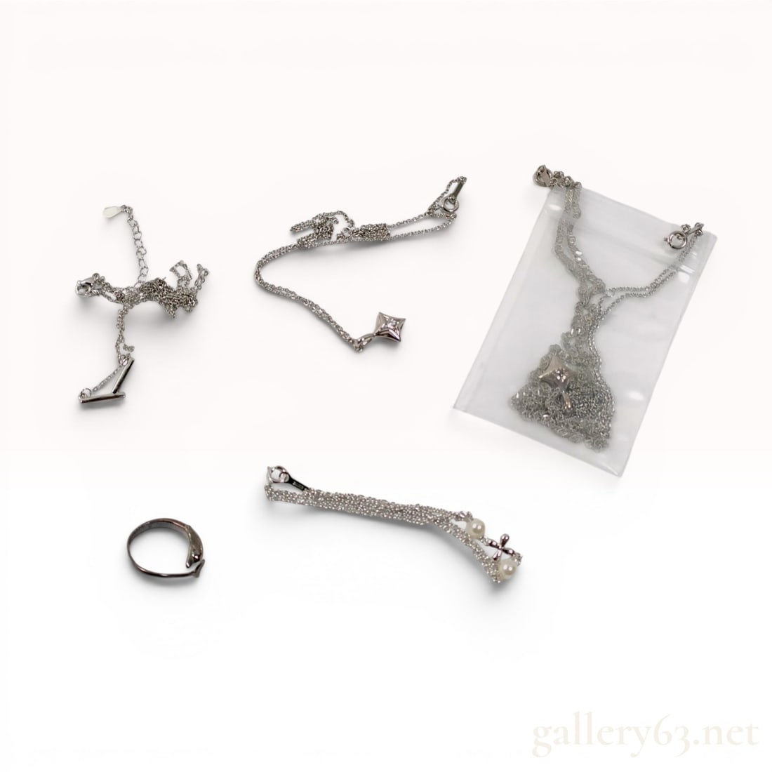 A Collection of Sterling Silver Jewelry Including Star Pendants and a Dolphin Ring: An assortment of contemporary sterling silver jewelry featuring star and T-bar motifs, including necklaces with fine cable chains and bolt ring clasps. The collection contains a multi-strand chain bra