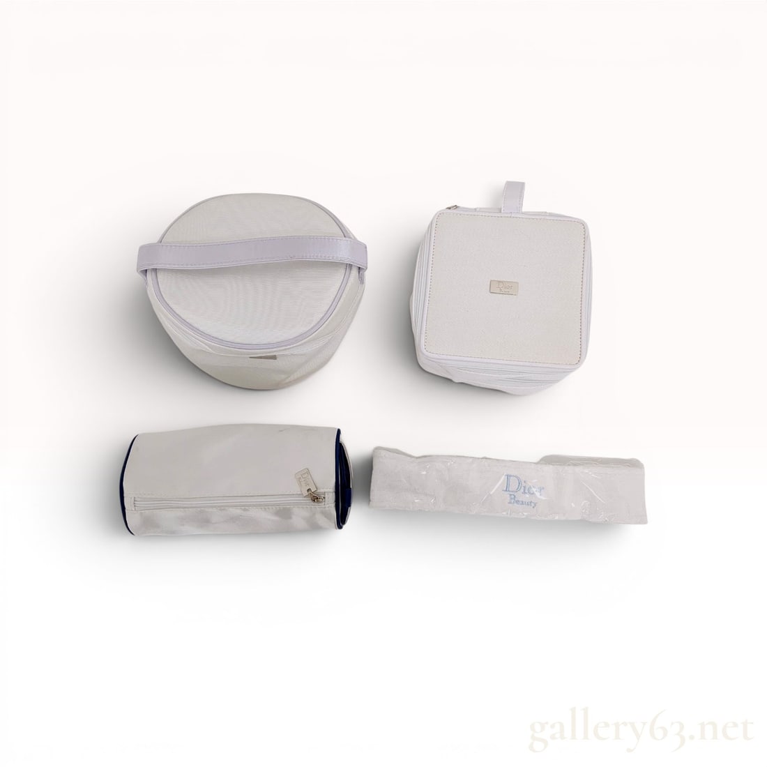 A Set of Christian Dior Beauty and Parfums Cosmetic Cases and Accessories: A set of Christian Dior cosmetic accessories from the Dior Beauty and Dior Parfums collections, likely contemporary promotional items. The collection includes a cylindrical vanity case, a square zippe