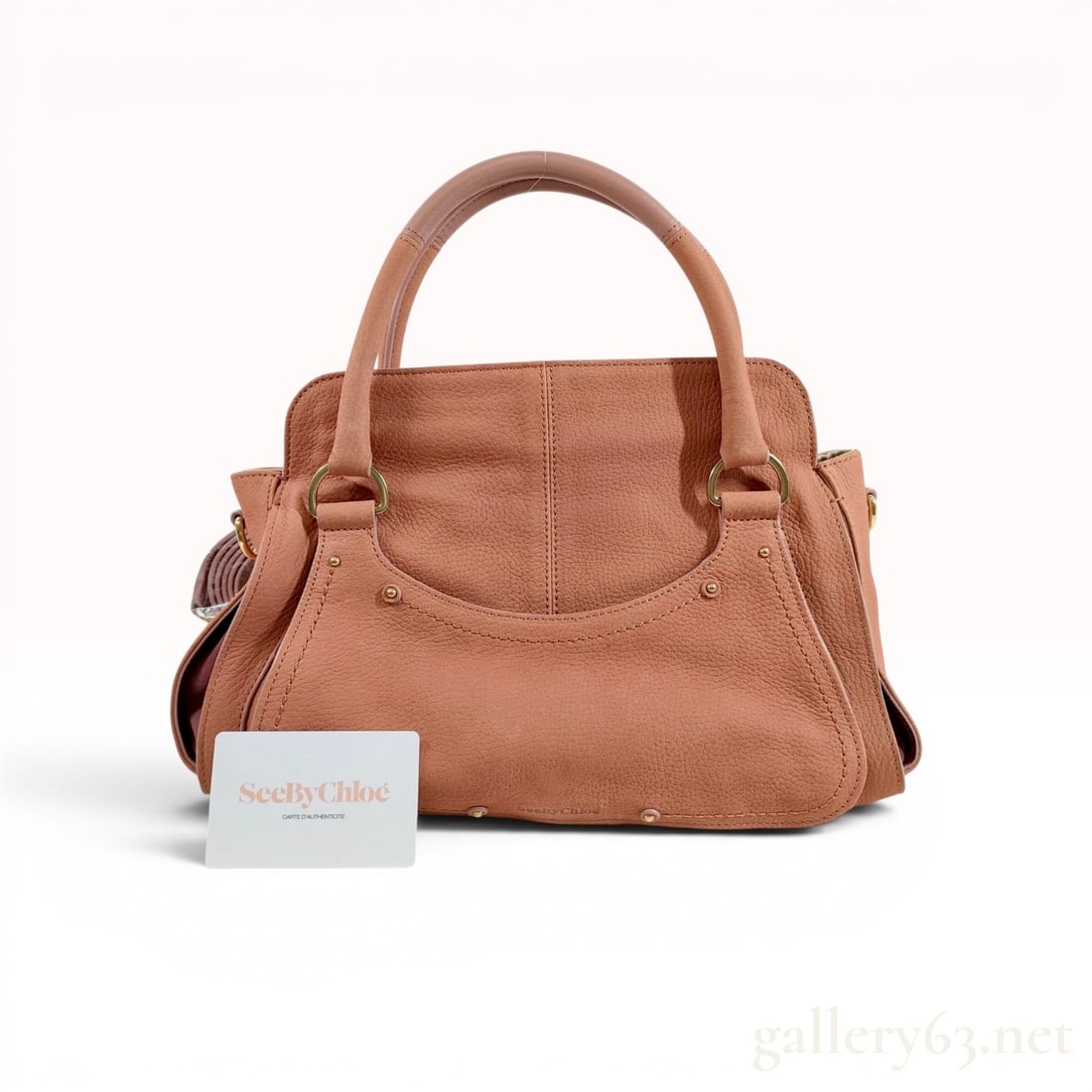 See by Chloe Miya Salmon Pebbled Leather 2-Way Satchel: See by Chloé Miya satchel crafted in salmon-colored pebbled leather with gold-tone hardware. The design features dual rolled top handles, central vertical seaming, a rear slip pocket with embos