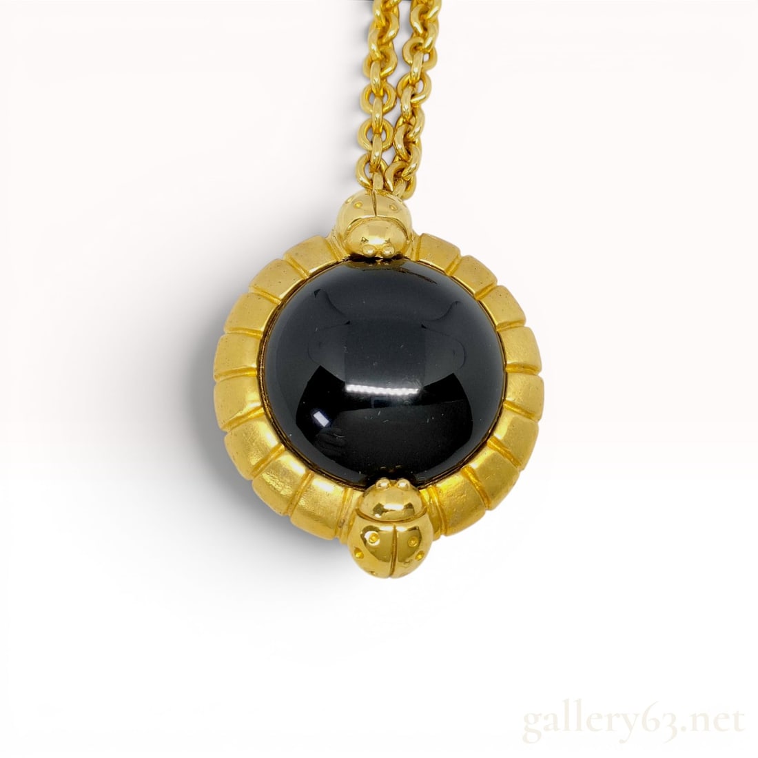 Lanvin Germany Gold-Tone and Black Cabochon Ladybug Pendant Necklace: Lanvin vintage pendant necklace, manufactured in Germany. The circular gold-tone pendant features a large domed black cabochon within a fluted frame accented by two stylized ladybug motifs. Suspended 