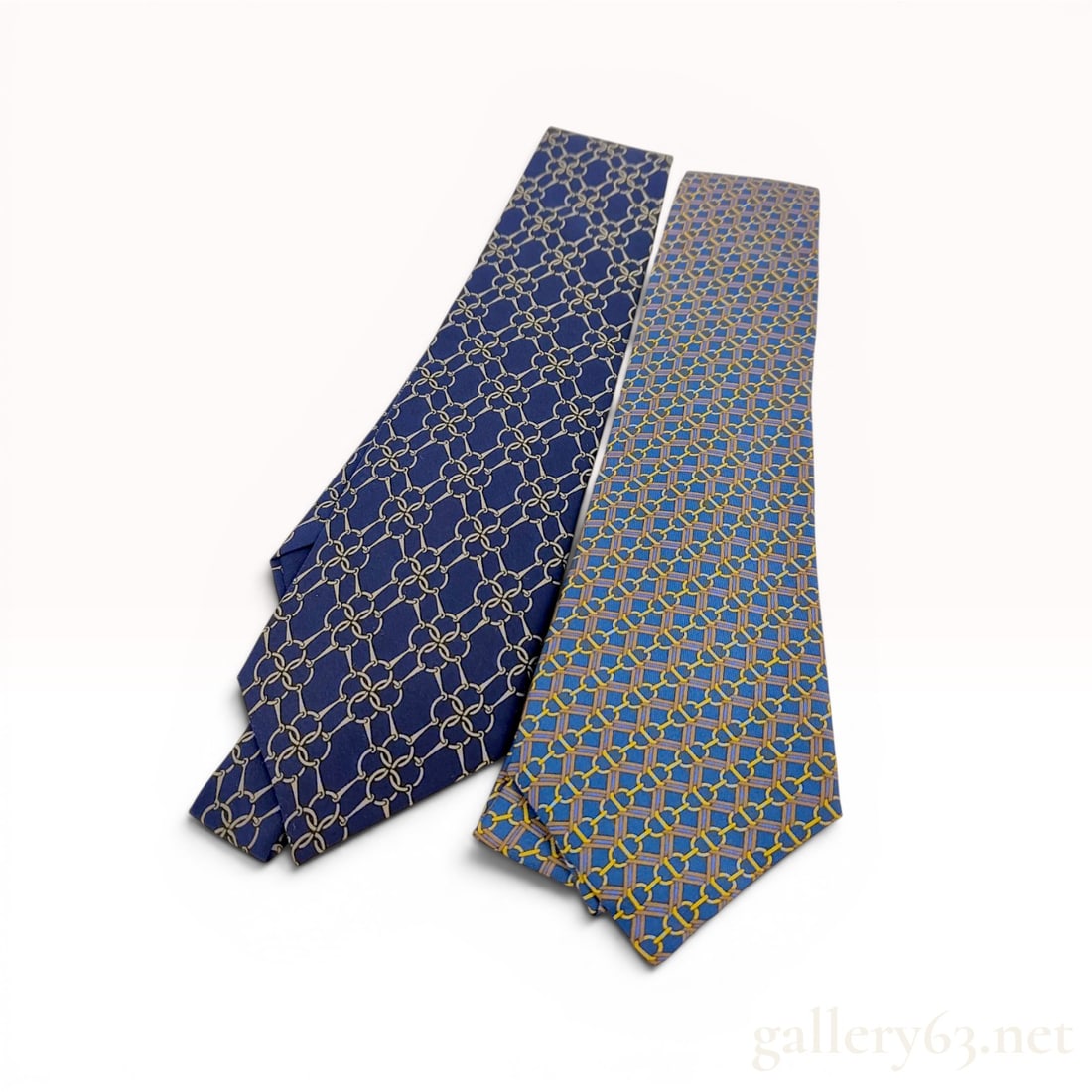 Two Hermes Paris Silk Men's Neckties with Original Packaging: Two Herm?¨s Paris 100% silk men's neckties made in France with equestrian-themed patterns. The navy blue tie features a repeating tan snaffle bit motif and is marked with pattern number 7203 UA, whil