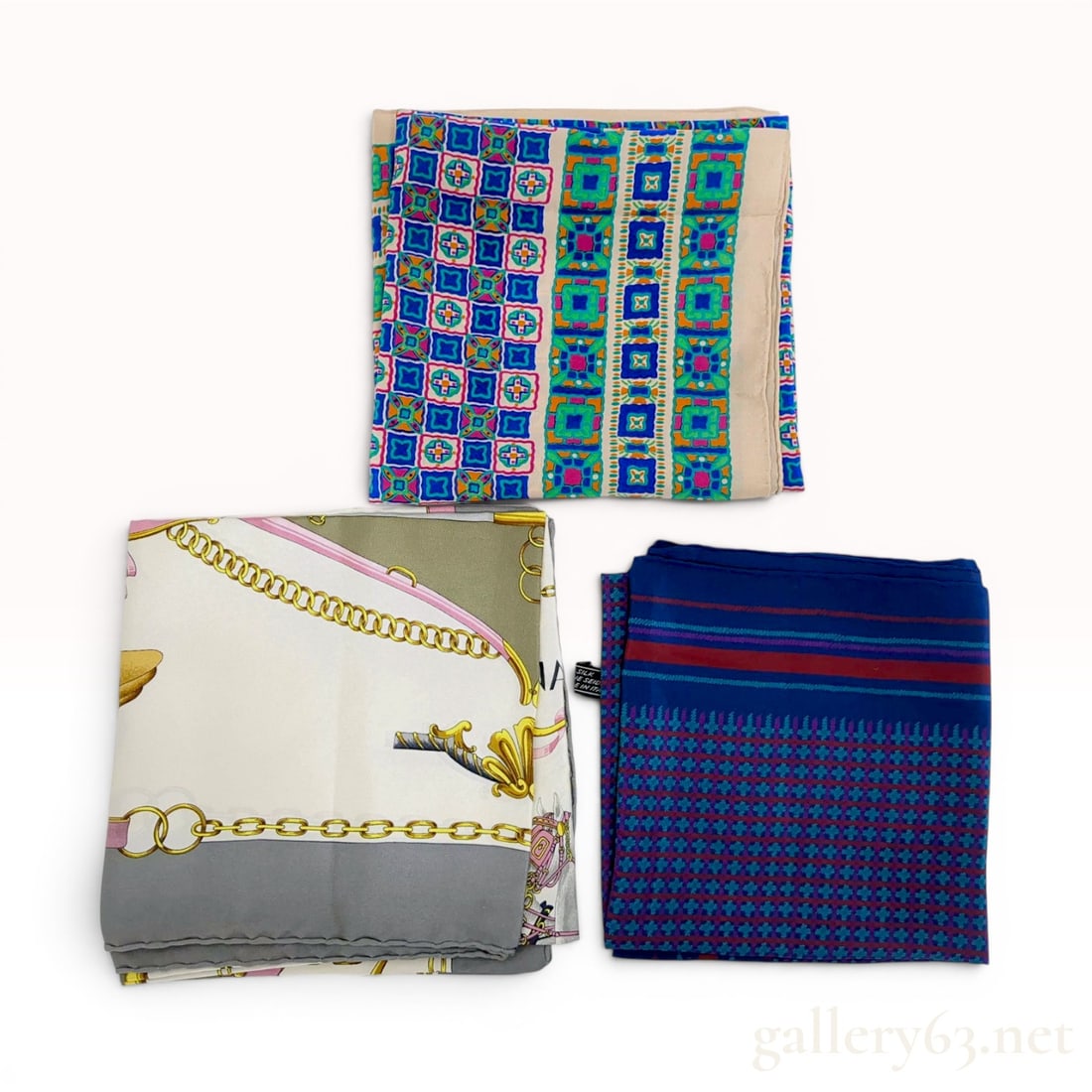 A Trio of Designer Silk Scarves by Celine, Givenchy, and Yves Saint Laurent: A trio of vintage designer silk scarves from the houses of Celine, Givenchy, and Yves Saint Laurent. The Celine scarf features an equestrian motif with gold-tone bits and pink buckled straps; the Give