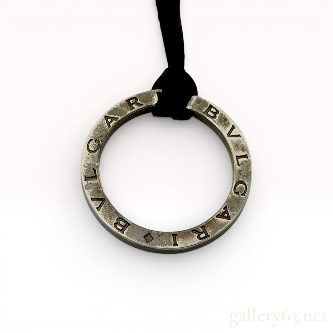 Bvlgari Bvlgari Sterling Silver Ring Pendant Cord Necklace w/Box: A Bvlgari sterling silver ring pendant necklace from the Bvlgari Bvlgari collection. The circular pendant is crafted from silver-colored metal and features the engraved brand name BVLGARI repeated twi