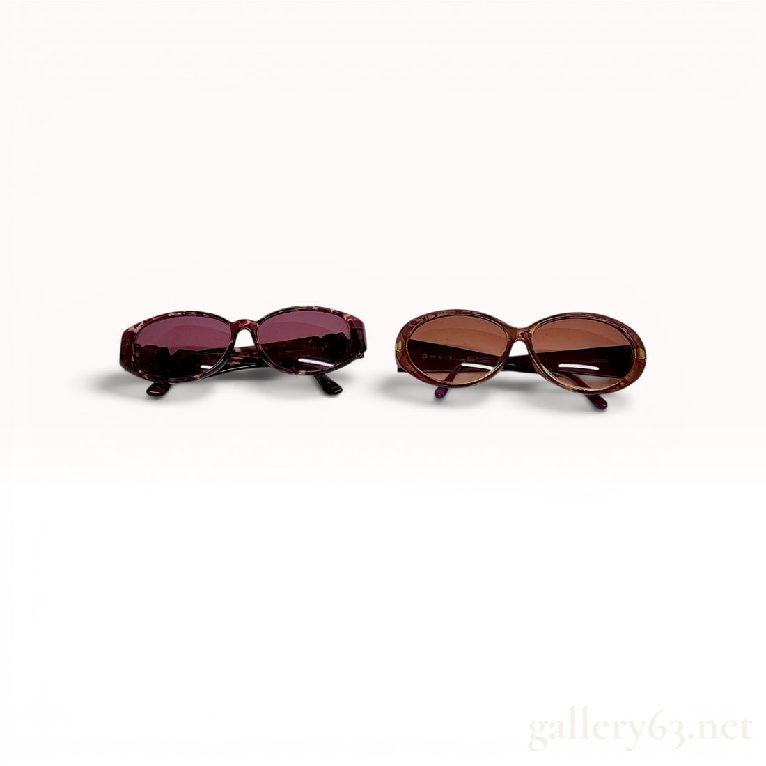 Two Pairs of Designer Sunglasses by Yves Saint Laurent and Christian Dior: Two pairs of designer sunglasses including a Christian Dior model 2384A and an Yves Saint Laurent model 31-5506. The Dior pair features oversized oval frames in translucent purple Optyl with gold-tone