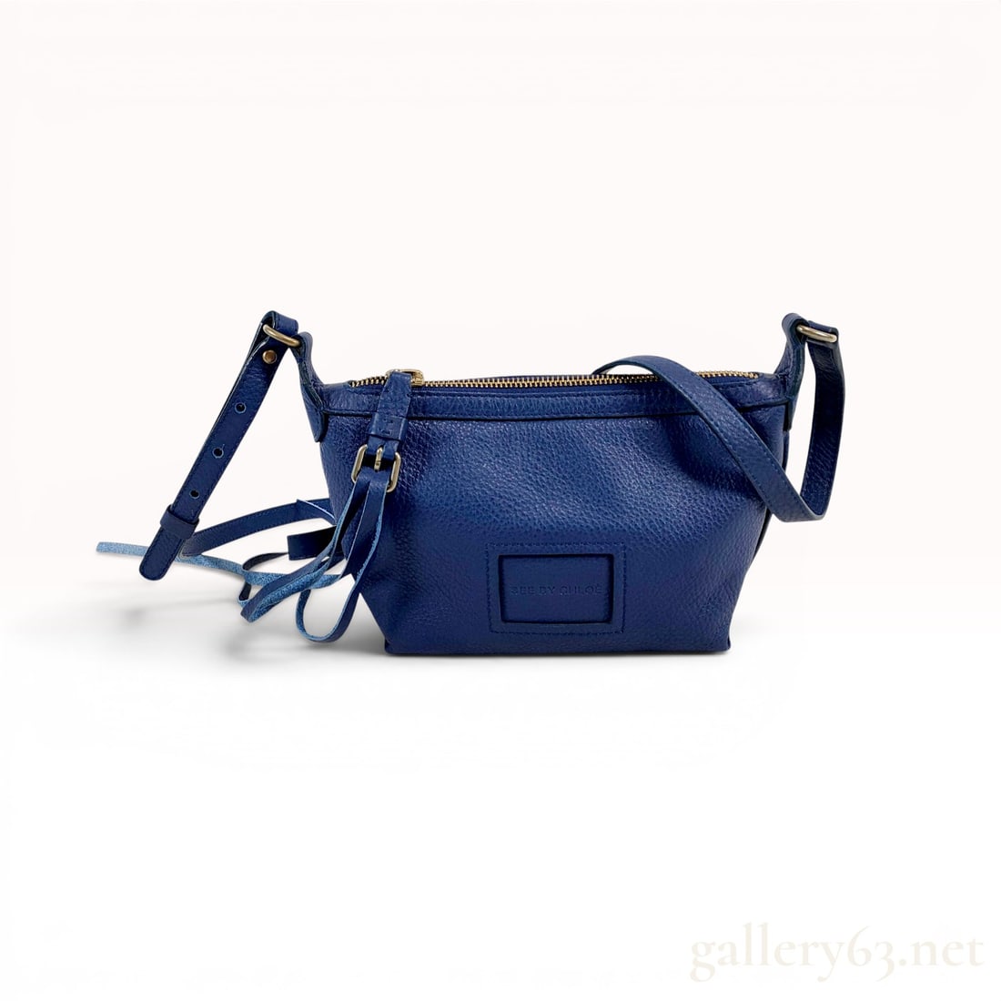 See by Chloe Cobalt Blue Pebbled Leather Crossbody Bag: See by Chloé crossbody bag in cobalt blue pebbled leather with gold-tone hardware. The bag features a tapered rectangular silhouette with a top zip closure, an adjustable shoulder strap with de
