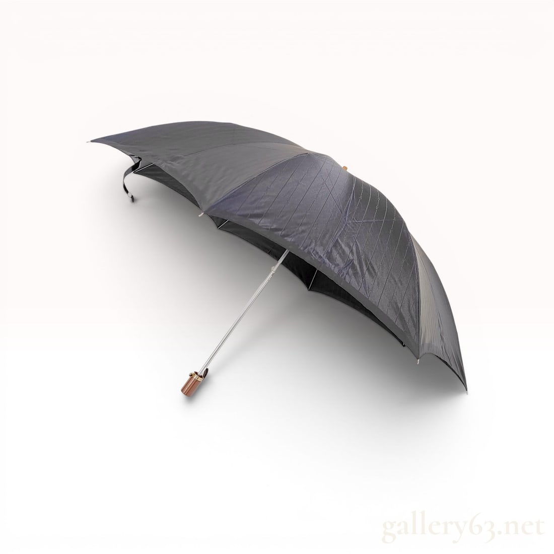 Yves Saint Laurent Monogrammed Folding Umbrella with Original Sleeve and Box: Yves Saint Laurent folding umbrella featuring a black synthetic canopy with a jacquard-weave pinstripe and repeating YSL monogram pattern. The piece is constructed with a telescoping metal shaft, eigh