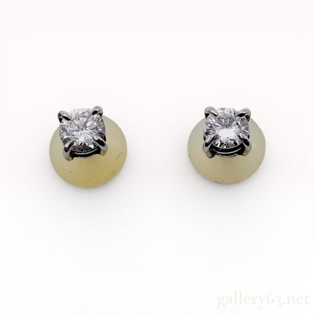 A Pair of Platinum and Diamond Solitaire Stud Earrings: A matched pair of solitaire stud earrings, each featuring a single round brilliant cut clear stone. The stones are secured within four-prong basket settings crafted in platinum. The earring posts are 