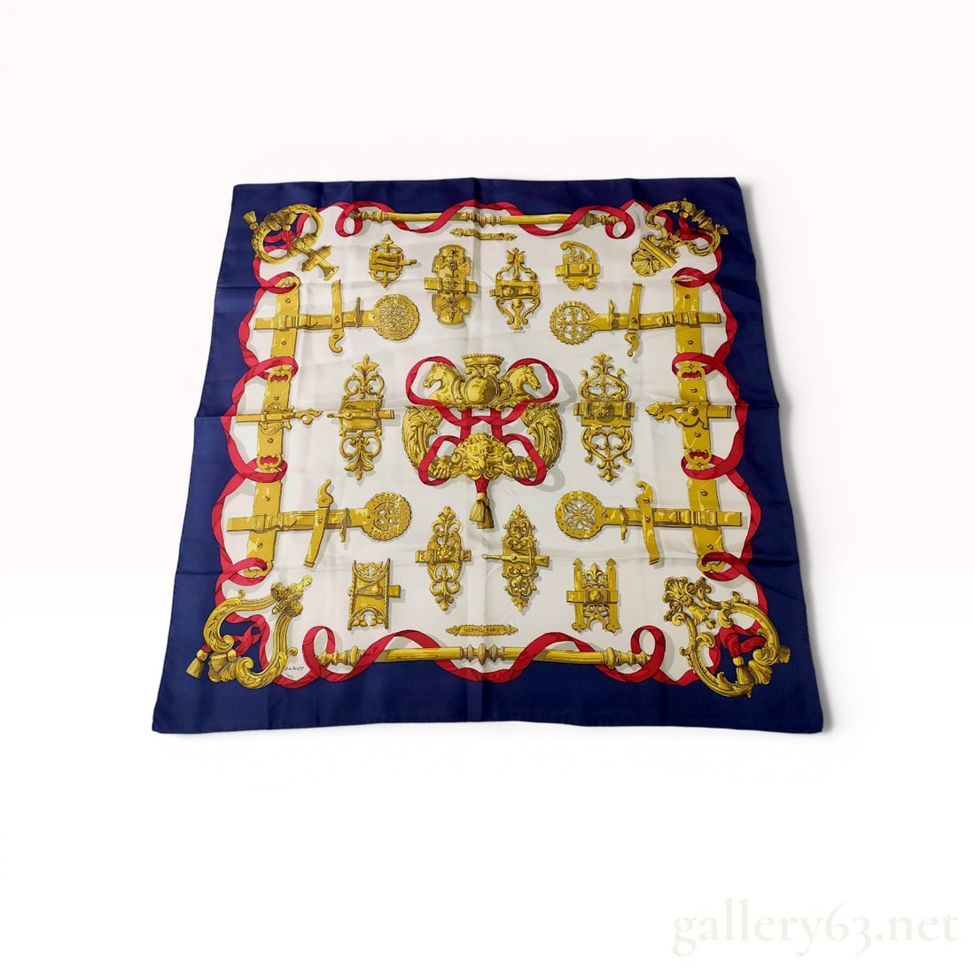 Hermes Ferronnerie Silk Twill Scarf by Caty Latham: Hermès silk twill scarf in the Ferronnerie pattern, designed by Caty Latham and first issued in 1970. The design features a collection of ornate gilded wrought-iron door hardware and red ribbon