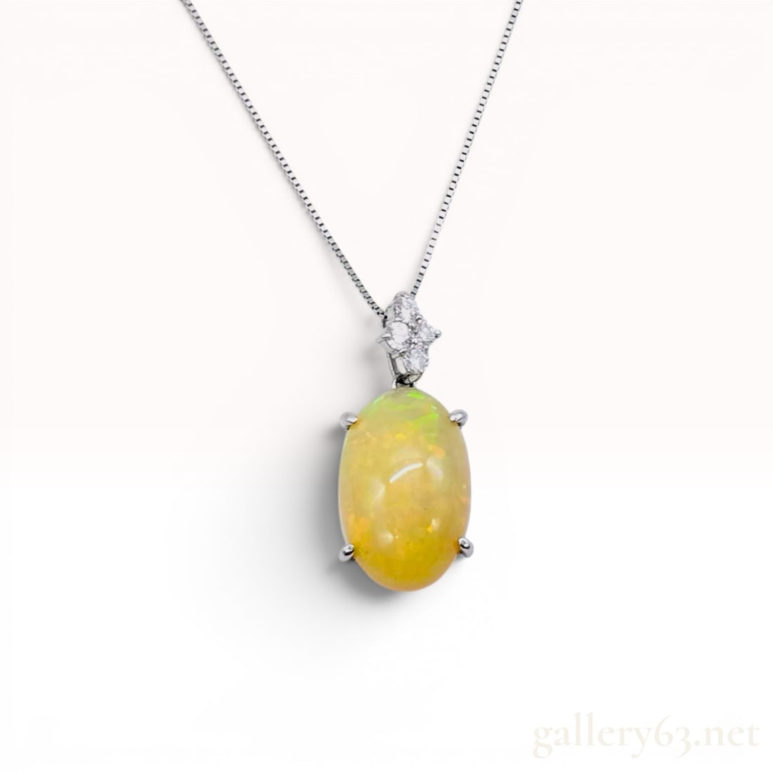Platinum and 9.56 Carat Precious Opal Pendant Necklace with Diamond Accents w/Box: Platinum adjustable pendant necklace featuring a large oval cabochon precious opal weighing 9.56 carats with yellow-orange body color and play-of-color. The pendant includes a floral-style cluster of 
