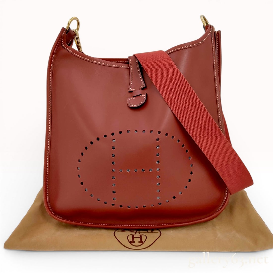 Hermes Evelyne II PM Rouge H Leather Shoulder Bag with Gold Hardware: This Hermes Evelyne II PM shoulder bag is crafted from smooth leather in the house's signature Rouge H, a deep reddish-brown colorway. As a second-generation model, it features the iconic perforated H