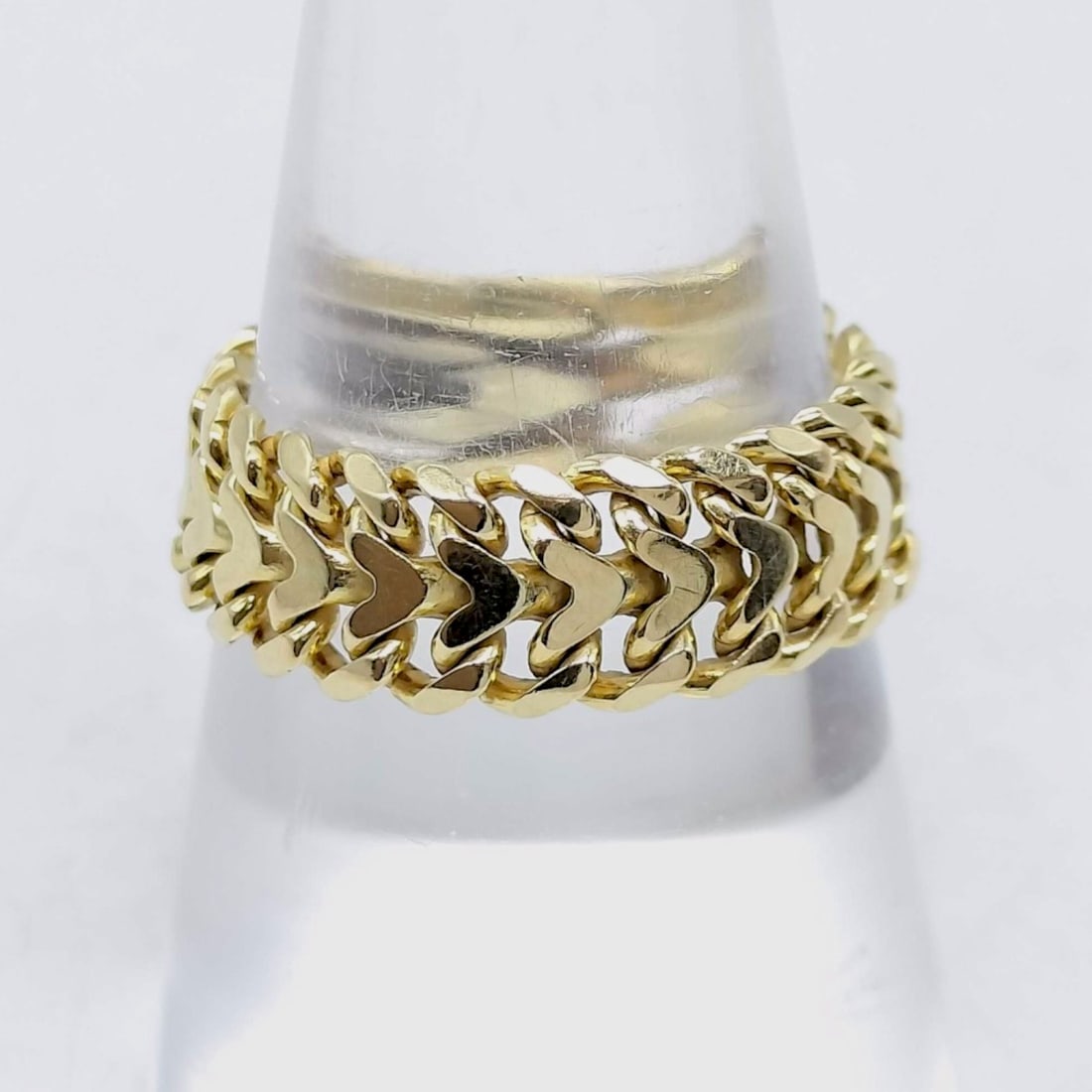 Solid 18K Yellow Gold Woven Chevron Link Band Ring: A wide decorative band ring crafted from solid 18 karat yellow gold. The ring features a flexible, multi-row design consisting of interlocking stylized chevron or heart-shaped links, creating a woven 