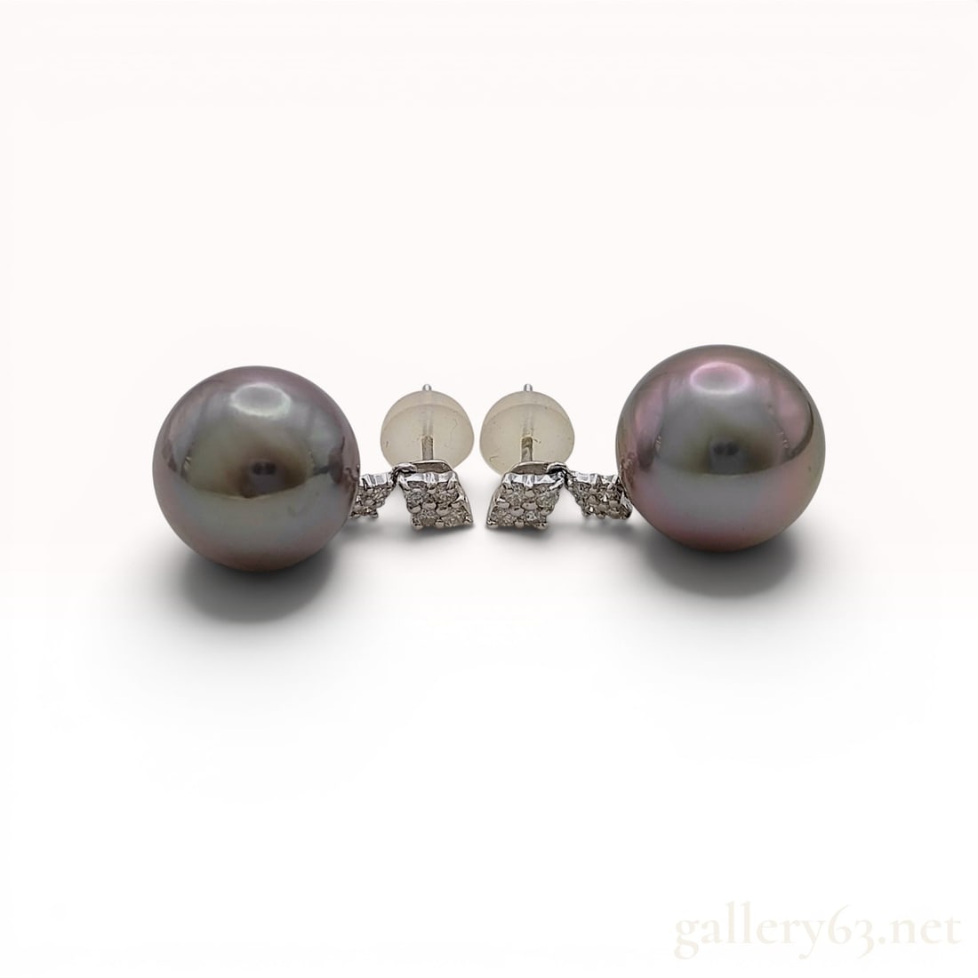 A Pair of Tahitian Cultured Pearl and Diamond Drop Earrings in 18K White Gold: A matched pair of Tahitian cultured pearl and diamond drop earrings. Each earring features a round Tahitian cultured pearl with dark gray body color and iridescent peacock overtones, suspended from an