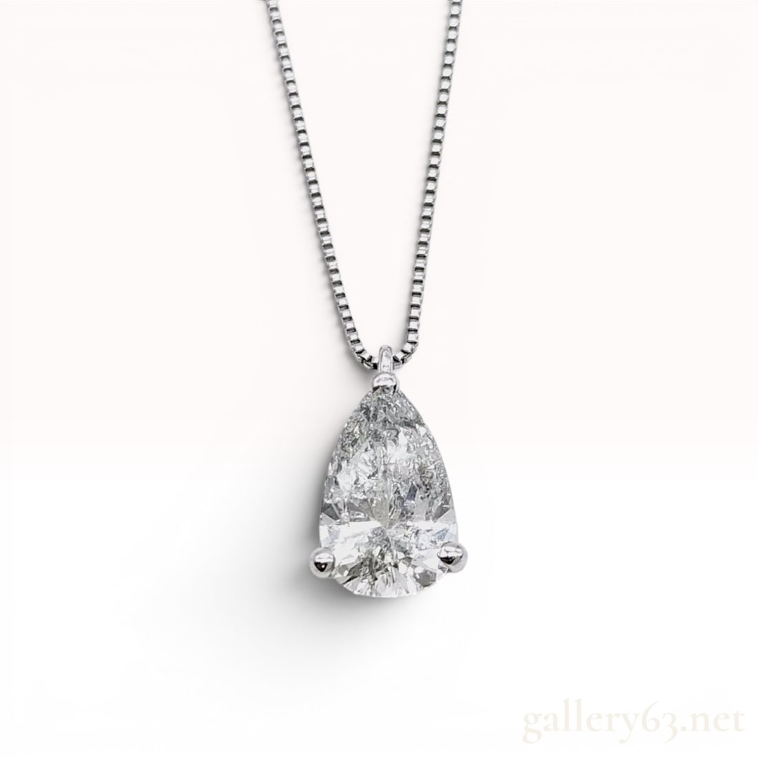 Platinum and 1.13 Carat Pear-Cut Diamond Solitaire Pendant Necklace w/Box: Platinum solitaire pendant necklace featuring a 1.13 carat pear brilliant-cut diamond. The diamond is secured in a three-prong platinum mounting and exhibits prominent salt and pepper style internal i